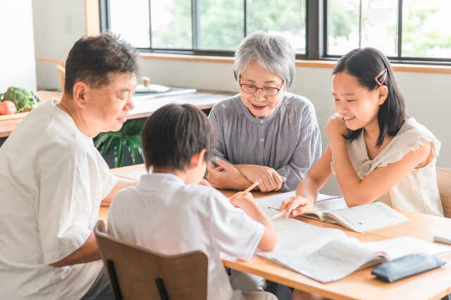 孫に勉強を教える老夫婦